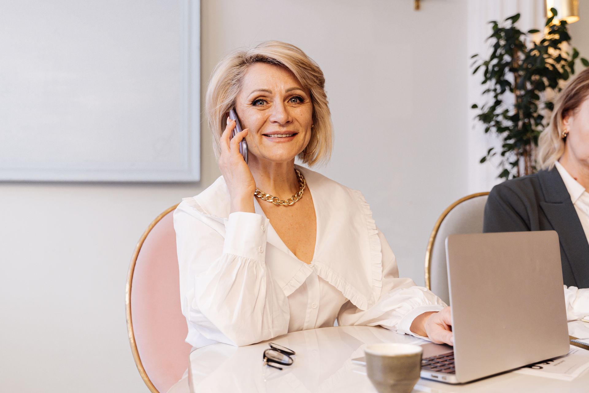 A smiling businesswoman on the phone at her desk