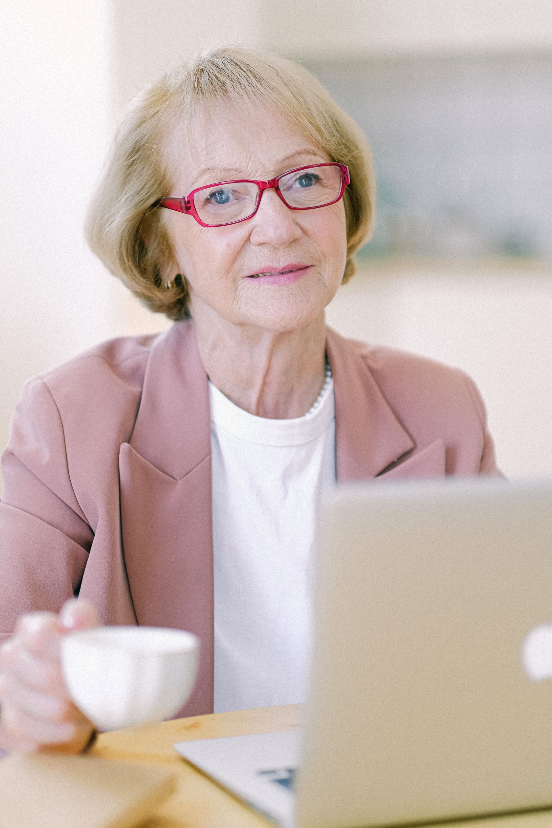 A woman working on a laptop at home with a cup of coffee